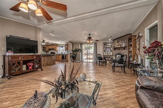 living room with a brick fireplace, a textured ceiling, light hardwood / wood-style flooring, and crown molding