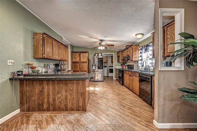 kitchen featuring kitchen peninsula, a textured ceiling, sink, black appliances, and light hardwood / wood-style floors