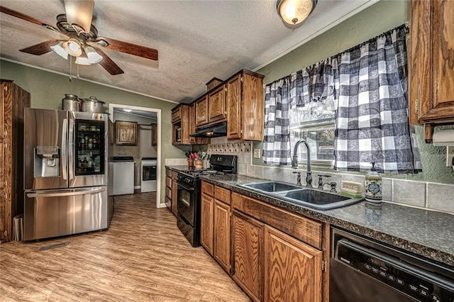 kitchen with a textured ceiling, light wood-type flooring, stainless steel appliances, and sink