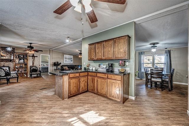 kitchen featuring kitchen peninsula, light hardwood / wood-style flooring, and a textured ceiling