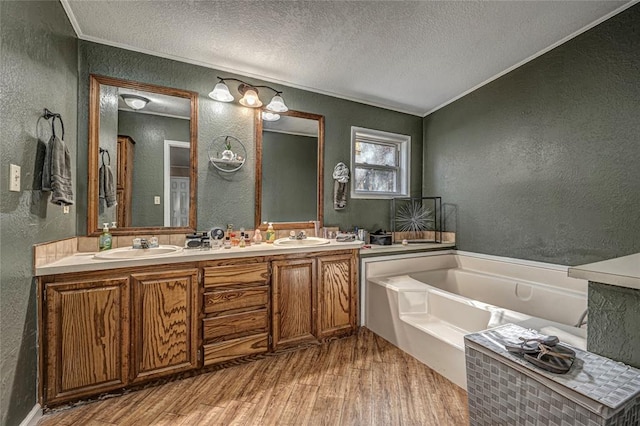 bathroom featuring a tub, ornamental molding, a textured ceiling, and hardwood / wood-style flooring