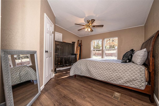 bedroom featuring ceiling fan, lofted ceiling, dark wood-type flooring, and ornamental molding