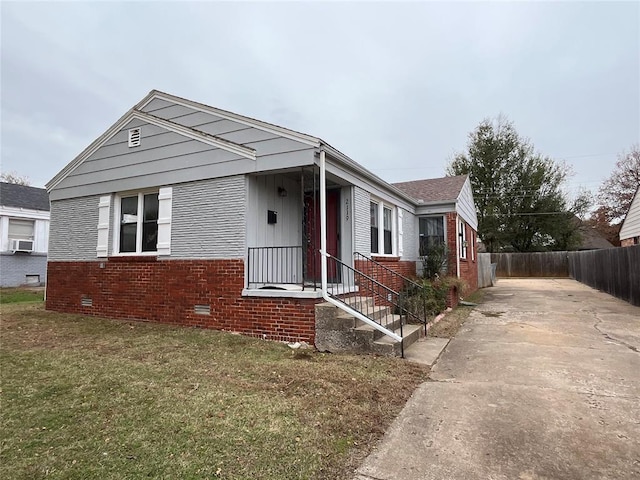 bungalow-style home featuring a front yard and cooling unit