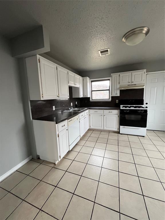 kitchen with white cabinets, light tile patterned floors, and white appliances