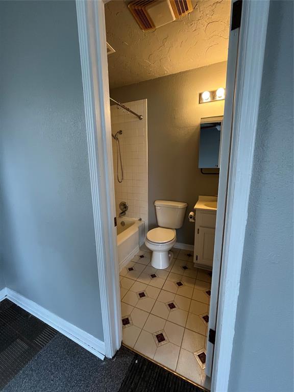 full bathroom featuring tiled shower / bath, tile patterned flooring, vanity, and toilet