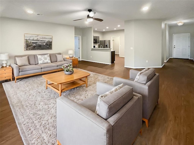 living room with ceiling fan and dark hardwood / wood-style floors