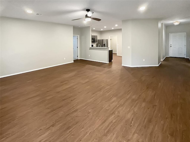 unfurnished living room with dark hardwood / wood-style flooring and ceiling fan