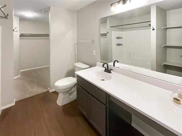 bathroom with vanity, hardwood / wood-style flooring, toilet, and walk in shower