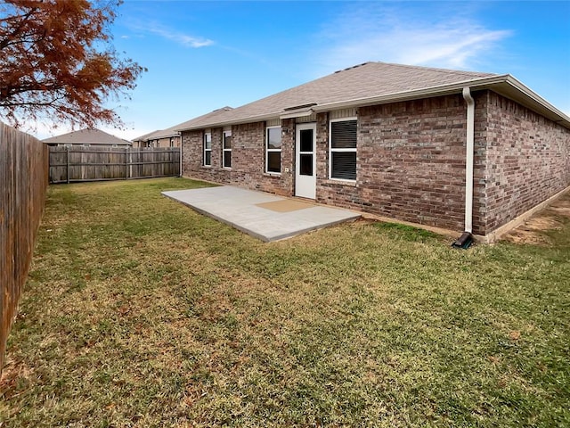 rear view of house with a yard and a patio