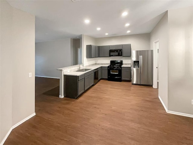 kitchen with black appliances, light wood-type flooring, and sink