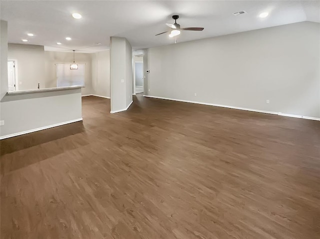 unfurnished living room featuring ceiling fan and dark wood-type flooring