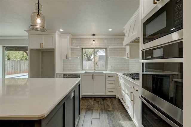 kitchen featuring appliances with stainless steel finishes, dark wood-type flooring, crown molding, pendant lighting, and white cabinetry