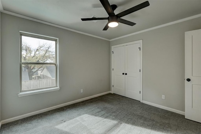 unfurnished bedroom with carpet, ceiling fan, crown molding, and a closet