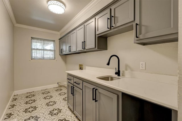 laundry area with cabinets, hookup for a washing machine, crown molding, sink, and light tile patterned flooring