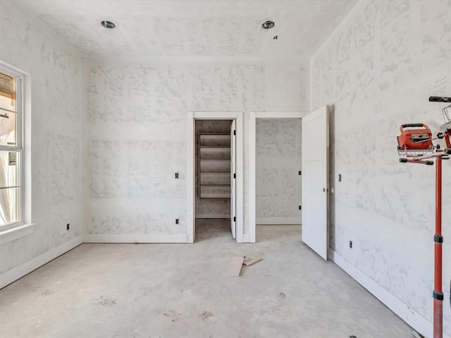 unfurnished bedroom with concrete flooring