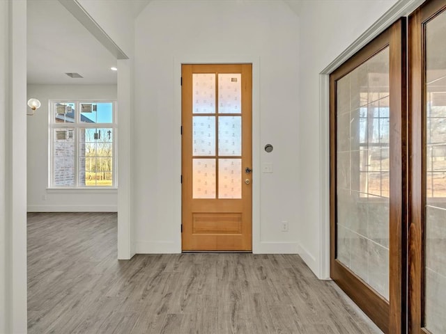 entryway featuring light wood-type flooring, baseboards, and visible vents