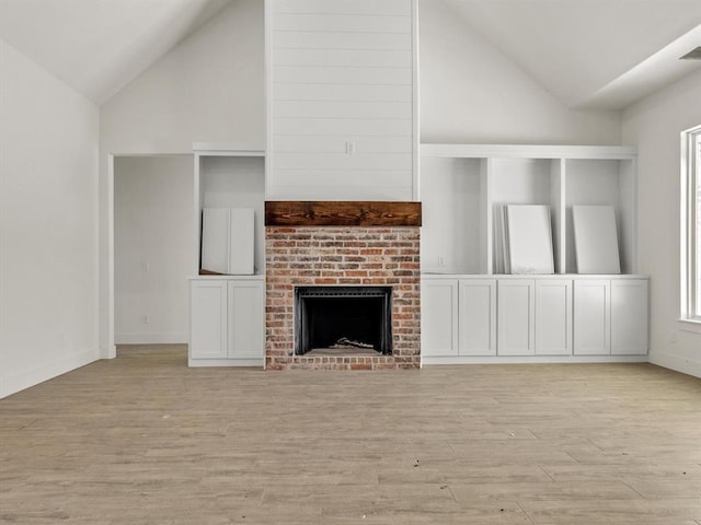 unfurnished living room with visible vents, high vaulted ceiling, light wood-style flooring, a fireplace, and baseboards