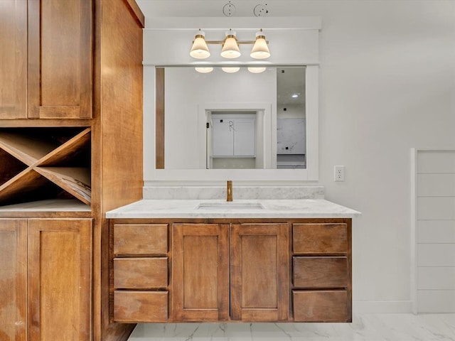 bathroom with marble finish floor, vanity, and baseboards