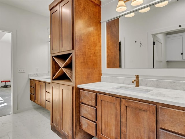 bathroom featuring marble finish floor, vanity, and baseboards