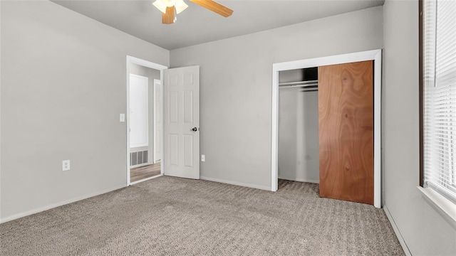 unfurnished bedroom featuring ceiling fan, a closet, and light colored carpet