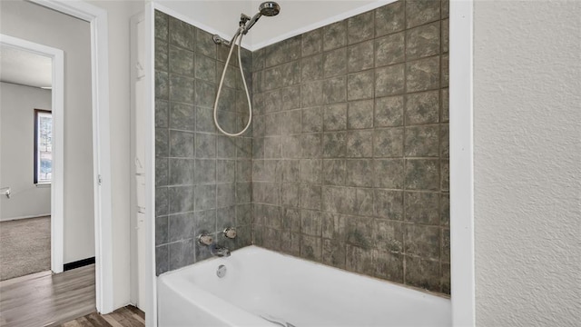 bathroom with wood-type flooring and tiled shower / bath combo