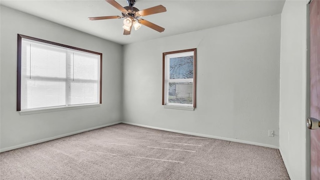 spare room featuring light carpet and ceiling fan