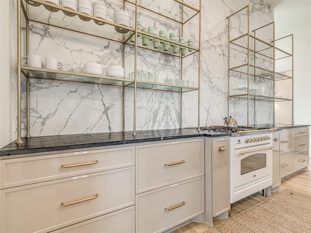 kitchen with backsplash, oven, and light wood-type flooring