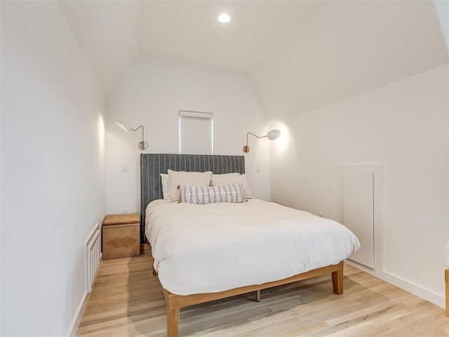 bedroom featuring light hardwood / wood-style floors and vaulted ceiling