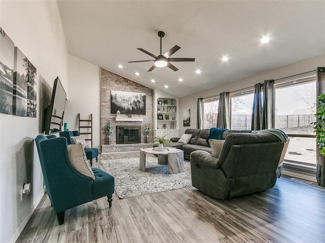 living room with ceiling fan, a fireplace, built in features, and hardwood / wood-style flooring