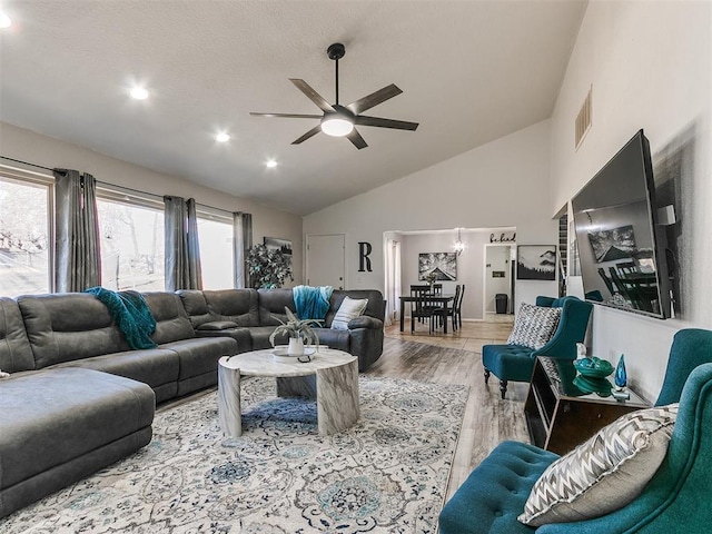 living room with light hardwood / wood-style floors, high vaulted ceiling, and ceiling fan