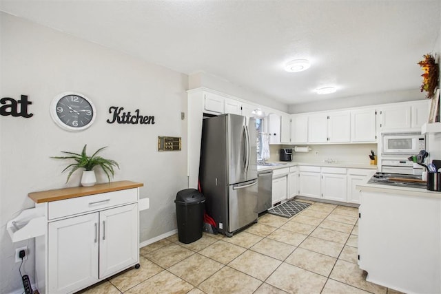 kitchen featuring appliances with stainless steel finishes, sink, white cabinetry, and light tile patterned flooring