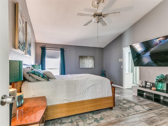 bedroom featuring ceiling fan, wood-type flooring, and lofted ceiling