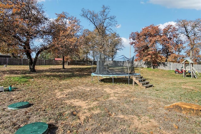 view of yard featuring a playground and a trampoline