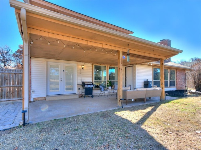 rear view of property featuring french doors, an outdoor hangout area, a yard, central AC, and a patio area