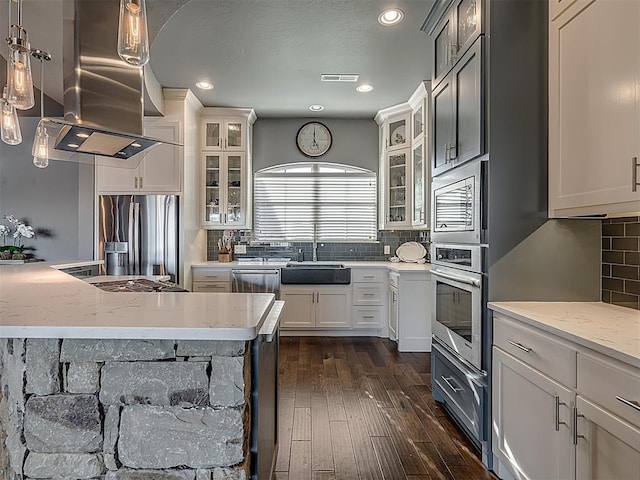 kitchen with light stone countertops, stainless steel appliances, dark wood-type flooring, pendant lighting, and white cabinets
