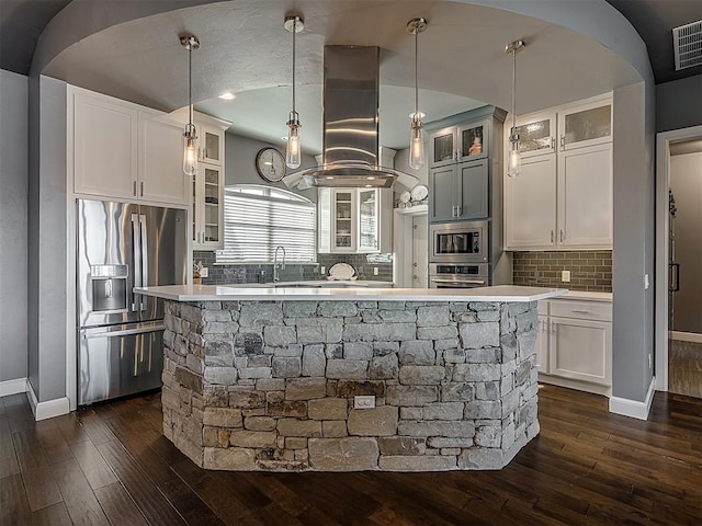kitchen featuring appliances with stainless steel finishes, dark hardwood / wood-style flooring, tasteful backsplash, and decorative light fixtures