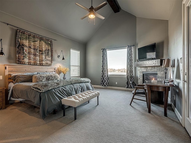 carpeted bedroom with ceiling fan, beam ceiling, a stone fireplace, and high vaulted ceiling