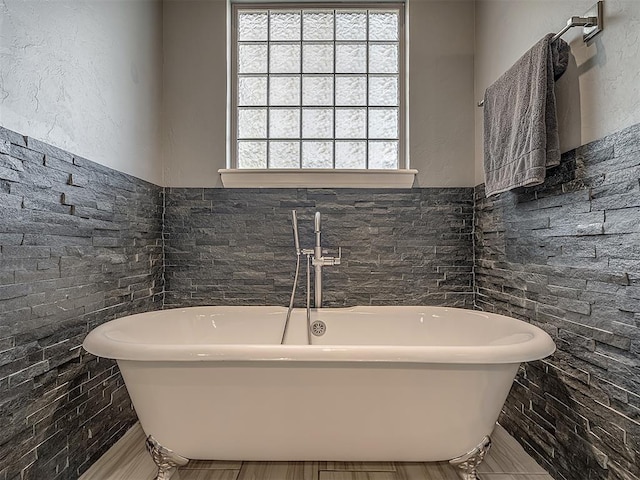 bathroom featuring a tub and tile walls