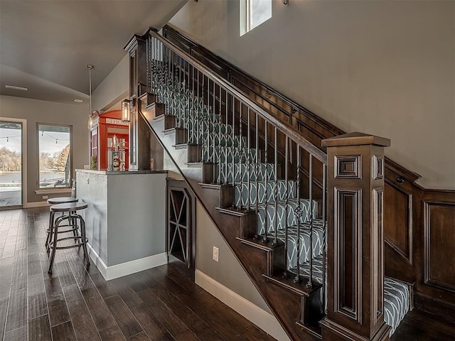 stairway featuring hardwood / wood-style flooring and vaulted ceiling