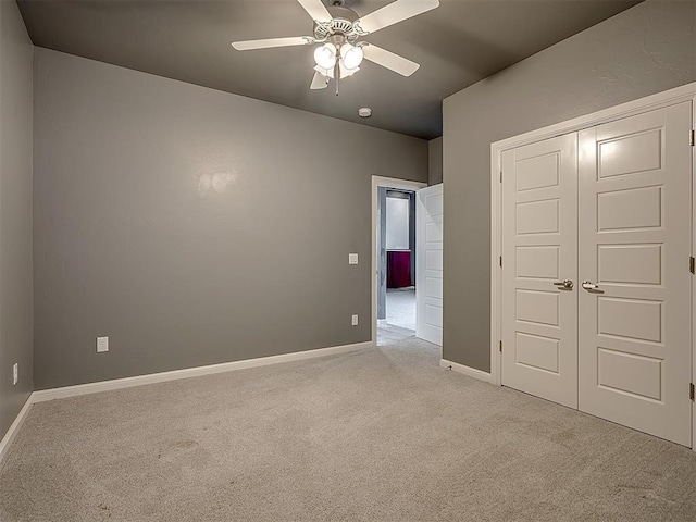 unfurnished bedroom featuring a closet, light colored carpet, and ceiling fan