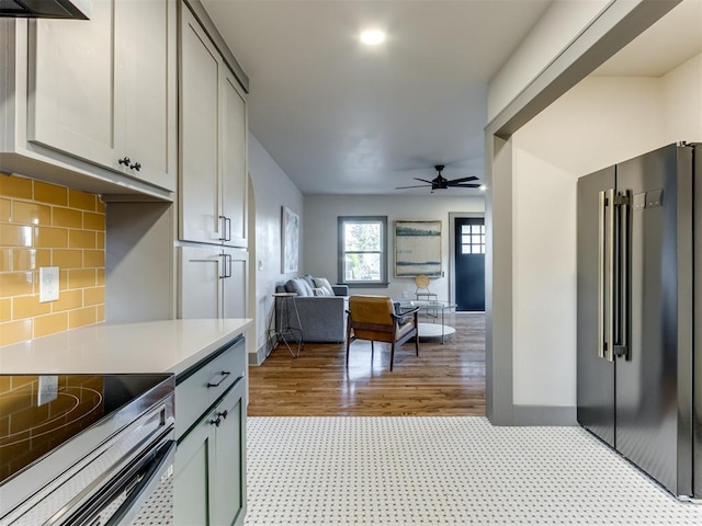 kitchen with ceiling fan, backsplash, light hardwood / wood-style floors, gray cabinets, and high end fridge