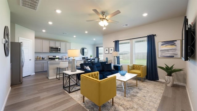 living area featuring light wood-style floors, recessed lighting, and visible vents