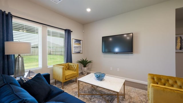 living area with light wood-type flooring, baseboards, and recessed lighting