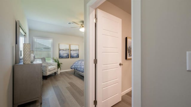 bedroom with ceiling fan, light wood-style flooring, and baseboards