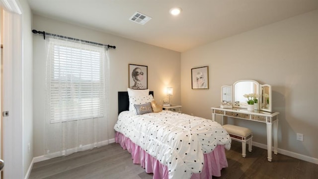 bedroom featuring visible vents, baseboards, and wood finished floors