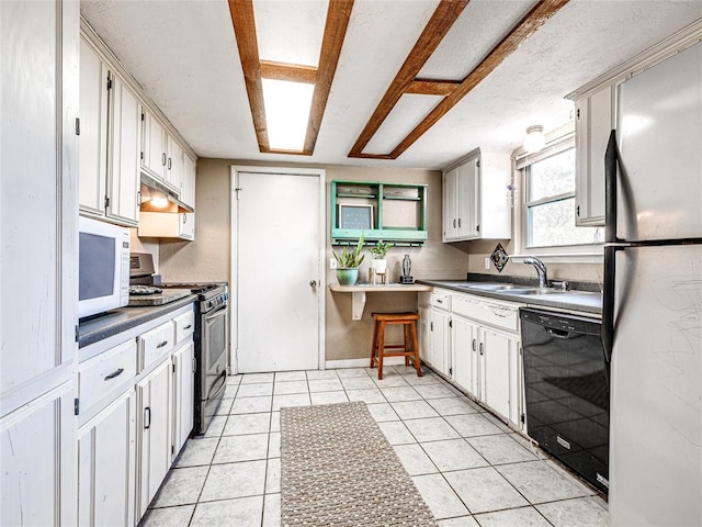 kitchen with sink, light tile patterned floors, white cabinets, and appliances with stainless steel finishes