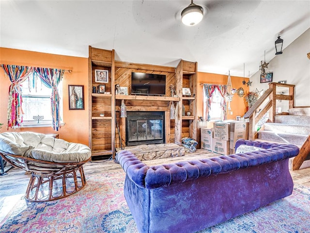 living room with vaulted ceiling, a wealth of natural light, and a fireplace