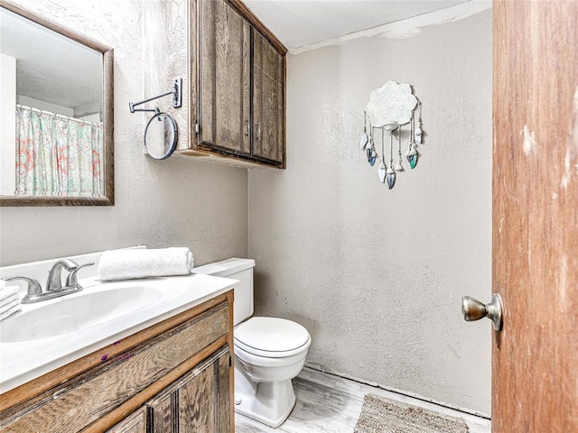 bathroom with vanity, hardwood / wood-style floors, and toilet