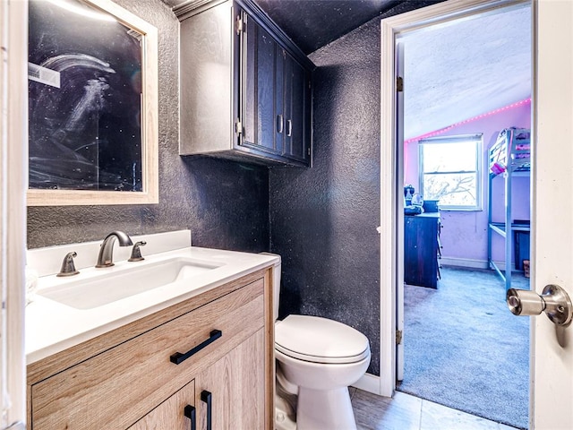 bathroom with tile patterned flooring, vanity, and toilet