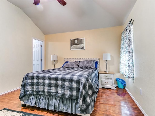 bedroom with hardwood / wood-style floors, vaulted ceiling, and ceiling fan